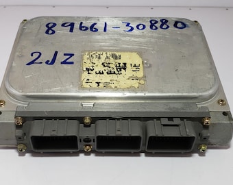 May include: A silver automotive engine control unit with the part number 89661-30880 and the code 2JZ printed on it. The unit has three connectors on the bottom.