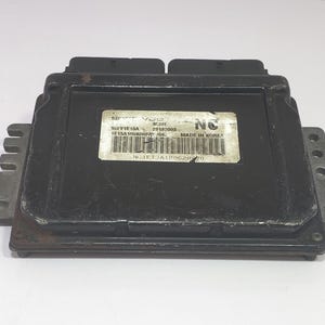 May include: A white ceramic mug with a black handle and the text "But First, Coffee" in a bold, black font. The mug is set against a blurred background, suggesting a cosy setting.