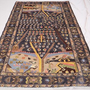 May include: A rectangular, hand-knotted rug with a dark blue field and a detailed tree of life design. The rug features a border with floral and geometric patterns, and the central design includes trees, birds, and other natural elements.