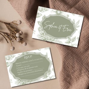 May include: A white RSVP card with a green floral border and the text "RSVP" in a green box. The text "R&eacute;ponse souhait&eacute;e avant le 1er juin 2025" is in French. The card also includes a list of options for guests to choose from, including "Accepte avec joie", "Regrette de ne pouvoir venir", "Nombre de personnes", and "Allergies ou restrictions alimentaires".