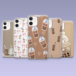 May include: A collection of phone cases with various designs. Some cases feature bubble tea illustrations with hearts, while others showcase bows and bubble tea cups. The cases are in shades of brown, pink, and beige, with a purple background.