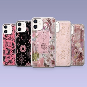 May include: A collection of five phone cases with various designs. The cases feature pink, black, and gold colors with celestial, floral, and tarot-inspired graphics. One case displays the text "THE READER".