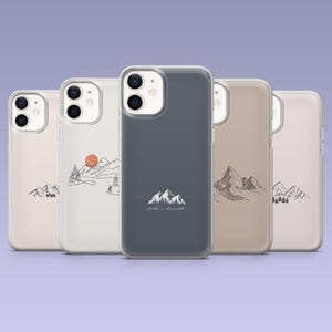 May include: A collection of five phone cases with mountain-themed designs. The cases feature illustrations of mountains, trees, and a sun, with the phrase "Take a breath" on one case. The cases are in various colors, including white, beige, and blue.