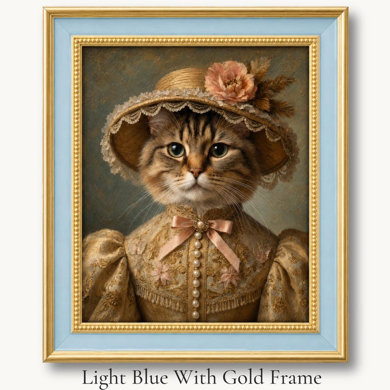 Tabby cat in a flowered straw bonnet and cream Victorian dress in a light blue with gold picture frame.