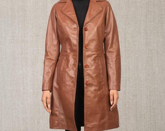 May include: A brown leather coat with a classic design. The coat features a collared neckline, button-down closure, and a tailored fit. The coat is knee-length and has a smooth, polished finish, suitable for various occasions.
