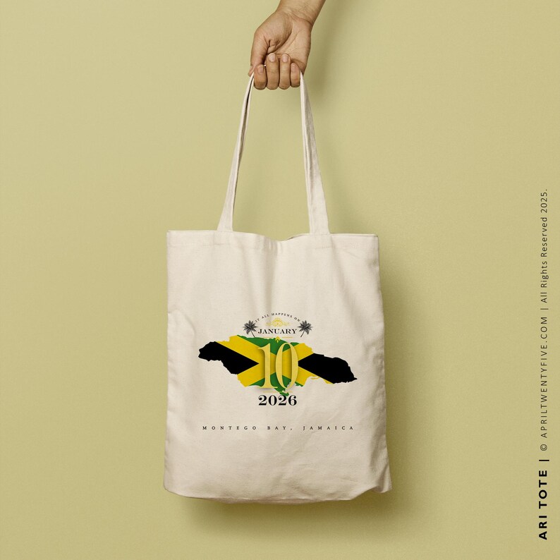 May include: A white tote bag with a graphic of the Jamaican flag in the shape of the island. The graphic includes the text "JANUARY 10 2026" and "MONTEGO BAY, JAMAICA".