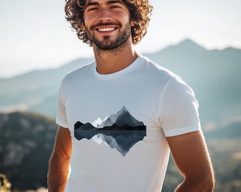 May include: White t-shirt with a graphic of a mountain range reflected in a lake. The mountains are shades of blue and gray.