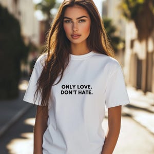 Könnte beinhalten: Weißes T-Shirt mit schwarzem Text, der "ONLY LOVE. DON'T HATE." lautet.