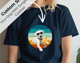 May include: Navy blue t-shirt with a graphic of a white dog wearing sunglasses and holding a cocktail. The dog is set against a circular background with horizontal stripes in teal, blue, yellow, and orange. Text on the shirt reads "Custom Shirt Your Dog With Sunglasses & Cocktail."