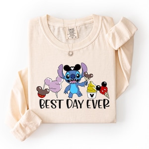 A beige long-sleeved t-shirt with a cartoon character and text printed on it.