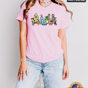 May include: Pink t-shirt with a graphic of Toy Story characters spelling out "MAMA".