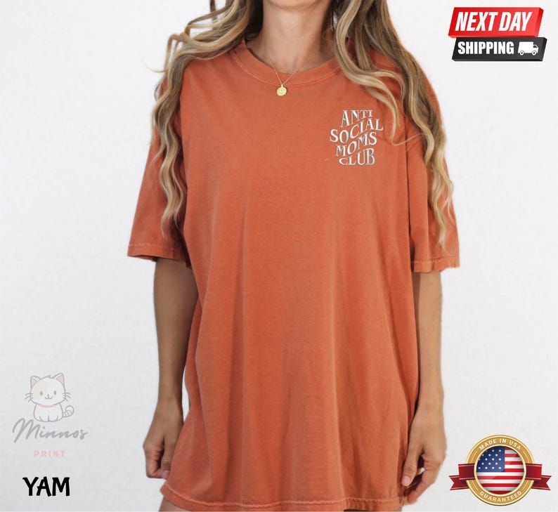 a woman wearing a red t-shirt with the text "Athletic Social Moms Club" printed on it.