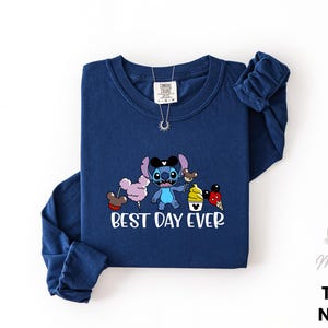A navy blue long-sleeved t-shirt with a cartoon character and text printed on it.