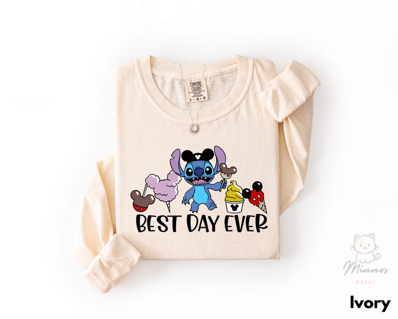 A beige long-sleeved t-shirt with a cartoon character and text printed on it.