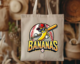 May include: Beige tote bag featuring a cartoon banana wearing sunglasses and a baseball cap, holding a baseball bat. The word "BANANAS" is in large, orange and yellow letters, with a baseball graphic. A small baseball is below the text.