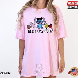 A woman wearing a pink t-shirt with a cartoon character and text printed on it.