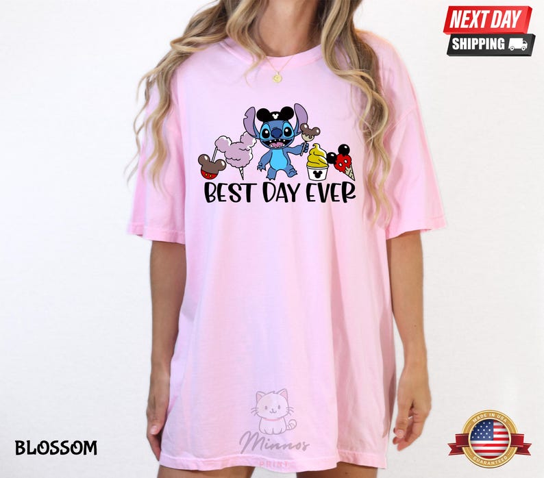 A woman wearing a pink t-shirt with a cartoon character and text printed on it.