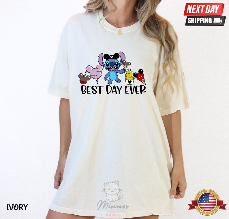 A white t-shirt with a graphic design featuring a cartoon character and the text "Best Day Ever".
