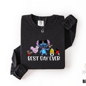 A black long-sleeved t-shirt with a graphic design featuring a cartoon character and the text "Best Day Ever" printed on it.