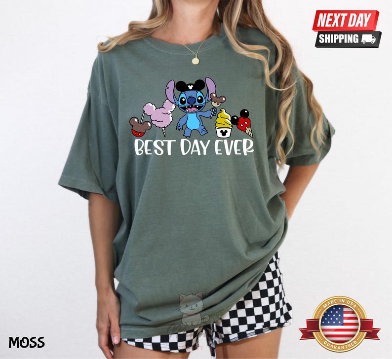 A woman wearing a green t-shirt with a cartoon character and text printed on it.