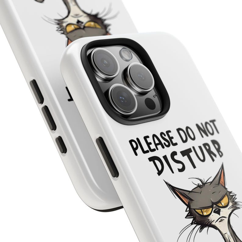 May include: White phone case with a black border featuring a cartoon cat with an angry expression. The text "PLEASE DO NOT DISTURB" is printed in black. The case has cutouts for the phone's camera and buttons.