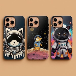 May include: Three phone cases featuring cartoon cats in astronaut suits. The cases have a dark blue, black, and colorful background. The cats are depicted in a spacesuit with a helmet. The cases are designed for a smartphone.