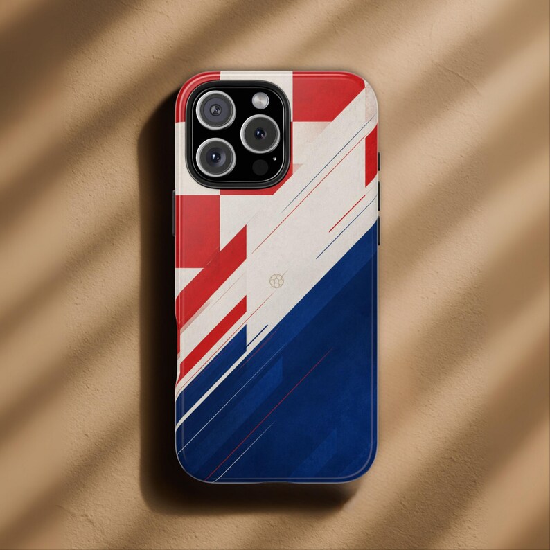May include: A smartphone case with a geometric design in red, white, and blue. The top portion features red and white blocks, while the bottom transitions to a blue gradient. Thin red and blue lines add detail.