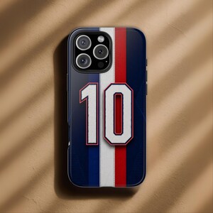 May include: A navy blue phone case with a vertical white, red, and white stripe design. The number "10" is prominently displayed in white with a red outline. The case has a glossy finish and a camera cutout.