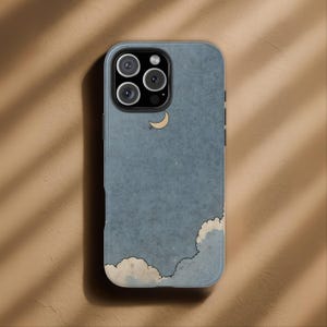 May include: A blue phone case featuring a whimsical design of a crescent moon and clouds. The case has a textured appearance and a camera cutout. The design is in a cartoon style, with a light beige moon and white and beige clouds.