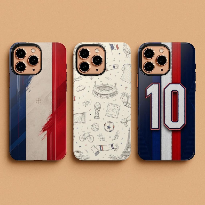 May include: Three phone cases with French-themed designs. One case features the French flag, another has a pattern of French icons, and the third displays a jersey design with the number 10. The cases are black with gold camera rings.