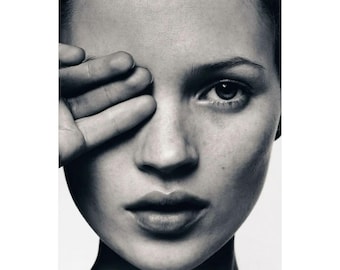 May include: Black and white portrait of a person with their hand covering one eye. The image is a close-up, focusing on the face and the hand. The skin has a smooth texture, and the lighting creates shadows.