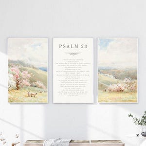 May include: A set of three framed art prints with watercolour landscape scenes. The side panels show rolling hills with flowering trees and grazing animals. The central panel displays the text "Psalm 23" and the associated verse.