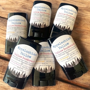May include: Six black deodorant sticks with white labels. The labels say "Appalachian Tallow Tallow Deodorant" and list the ingredients as 100% Grass Fed Beef Tallow, Coconut Oil, Arrowroot Powder, Magnesium Hydroxide, and Essential Oil. The scents are "Sweet Orange" and "Berry/Vanilla".