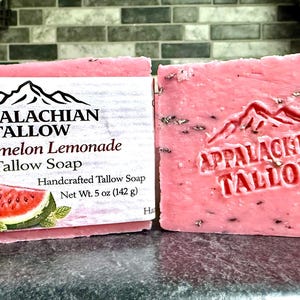 May include: Two pink bars of Appalachian Tallow Watermelon Lemonade Tallow Soap. One bar has a label with a watermelon and lemon illustration. The other bar has the brand name and mountain logo embossed. Each bar weighs 5 oz (142 g).