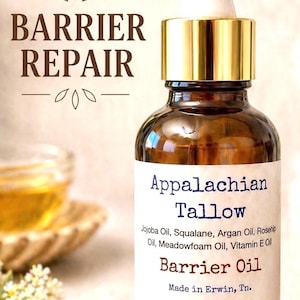 May include: A brown glass bottle of Appalachian Tallow Barrier Oil with a gold cap and white dropper. The label lists ingredients like Jojoba Oil and Vitamin E Oil. Text reads "Barrier Repair".