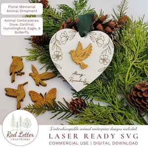 Può includere: Un ornamento floreale commemorativo per animali con centrotavola intercambiabili. L'ornamento a forma di cuore presenta una colomba di legno e le parole "Always Remembered". Ulteriori centrotavola di animali in legno includono un cardinale, un colibrì, un'aquila e una farfalla.