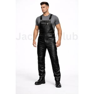 May include: Black leather overalls with adjustable straps, a front zipper, and multiple pockets. The overalls are worn with a gray t-shirt and black boots. The overall design is sleek and modern.