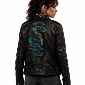 May include: Black leather jacket with a distressed finish, featuring a teal and yellow embroidered snake design on the back. The jacket has a classic biker style with a zipper closure, studded accents, and a tailored fit.