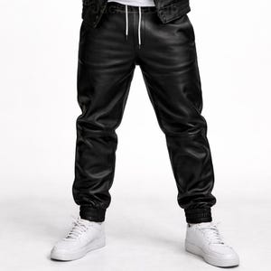 Puede incluir: Pantalones deportivos de cuero negro con cintura con cord&oacute;n y pu&ntilde;os el&aacute;sticos. Los pantalones se combinan con zapatillas blancas. Los pantalones de cuero tienen un corte relajado.