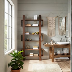 May include: A bathroom interior with a dark wood shelving unit displaying books, gold bowls, and ornaments. A macrame wall hanging and mirror are on the wall. A wooden vanity with a white sink and a potted plant add to the room's aesthetic.