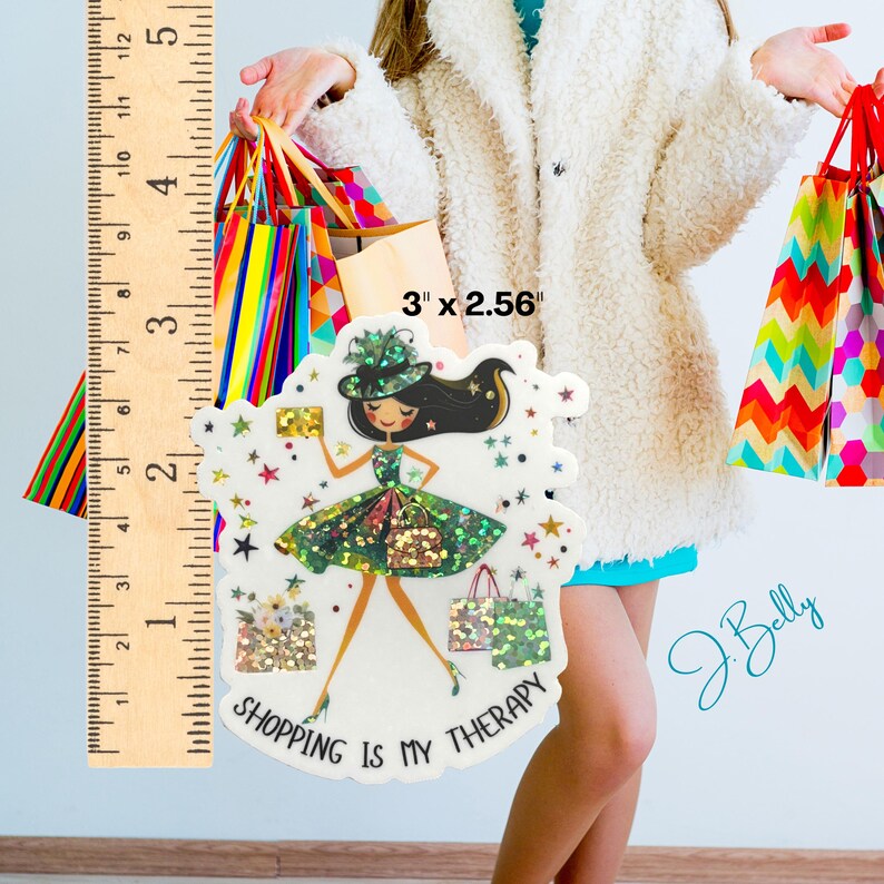 May include: A decorative sticker featuring a fashion illustration of a woman in a green dress and hat, holding a gold clutch and shopping bags. The sticker is approximately 3 inches by 2.56 inches and has the text "SHOPPING IS MY THERAPY".