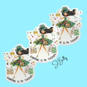 May include: Three stickers featuring a cartoon woman in a green dress and hat, holding a gold rectangle and shopping bags. The text "SHOPPING IS MY THERAPY" is written on the stickers. The stickers have a glittery effect and are on a light blue background.