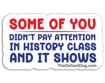 May include: A rectangular sticker with a white background and rounded edges. The text reads in red and blue: SOME OF YOU DIDN'T PAY ATTENTION IN HISTORY CLASS AND IT SHOWS. The website TheDefiantDog.com is printed in small black text at the bottom.