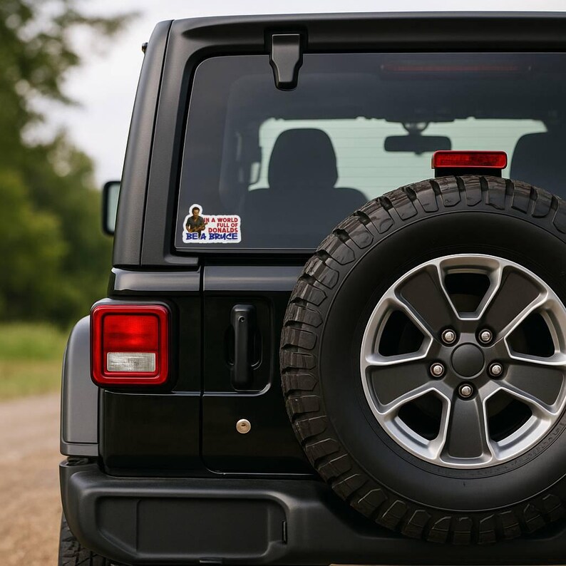 In a World Full of Donalds Be a Bruce political bumper sticker on Jeep rear window protest vinyl car decal