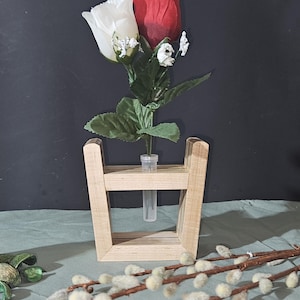 May include: A wooden vase with a clear glass tube holding a red and white rose. The vase has a square frame design. The background is a dark gray color. Decorative elements include an owl figurine and pussy willow branches.