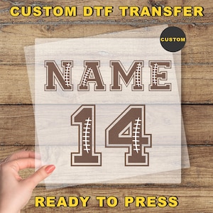 May include: A brown DTF transfer with the word "NAME" and the number "14" in a football-style font. The transfer is ready to press and includes the text "CUSTOM DTF TRANSFER" and "READY TO PRESS".