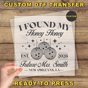 May include: A custom DTF transfer with the text "I FOUND MY Honey Honey" above three disco ball illustrations. Below the disco balls is "EST. 2026" and "Future Mrs. Smith - NEW ORLEANS, LA-". The words "CUSTOM" and "READY TO PRESS" are also visible.