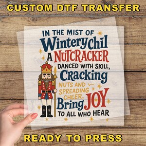 May include: A DTF transfer featuring a Nutcracker design with text. The design includes a Nutcracker illustration in a red and gold uniform, with text that reads "Winterychil", "Nutcracker", "Cracking", and "Bring Joy".