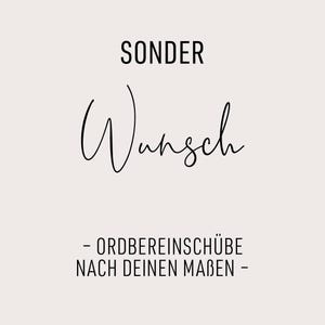 May include: A light beige background with black text. The word "SONDER" is at the top, followed by the word "Wunsch" in cursive script. Below, the text reads "- ORDBEREINSCHÜBE NACH DEINEN MABEN -."