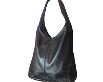 May include: A black hobo bag with a textured surface and a single shoulder strap. The bag features a vertical seam running down the center of the front panel, creating a structured yet slouchy silhouette with a wide opening at the top.